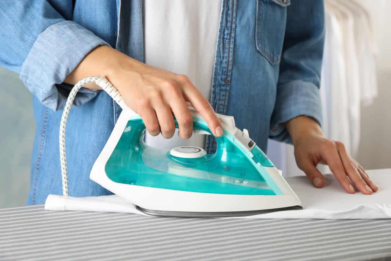 young woman ironing shirt on ironing board close 2021 09 02 20 14 50 utc