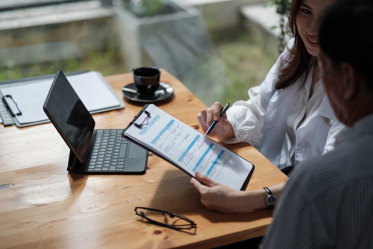 female health insurance broker presenting his insurance benefits to businessman fill out insurance policy. to prevent future incidents.