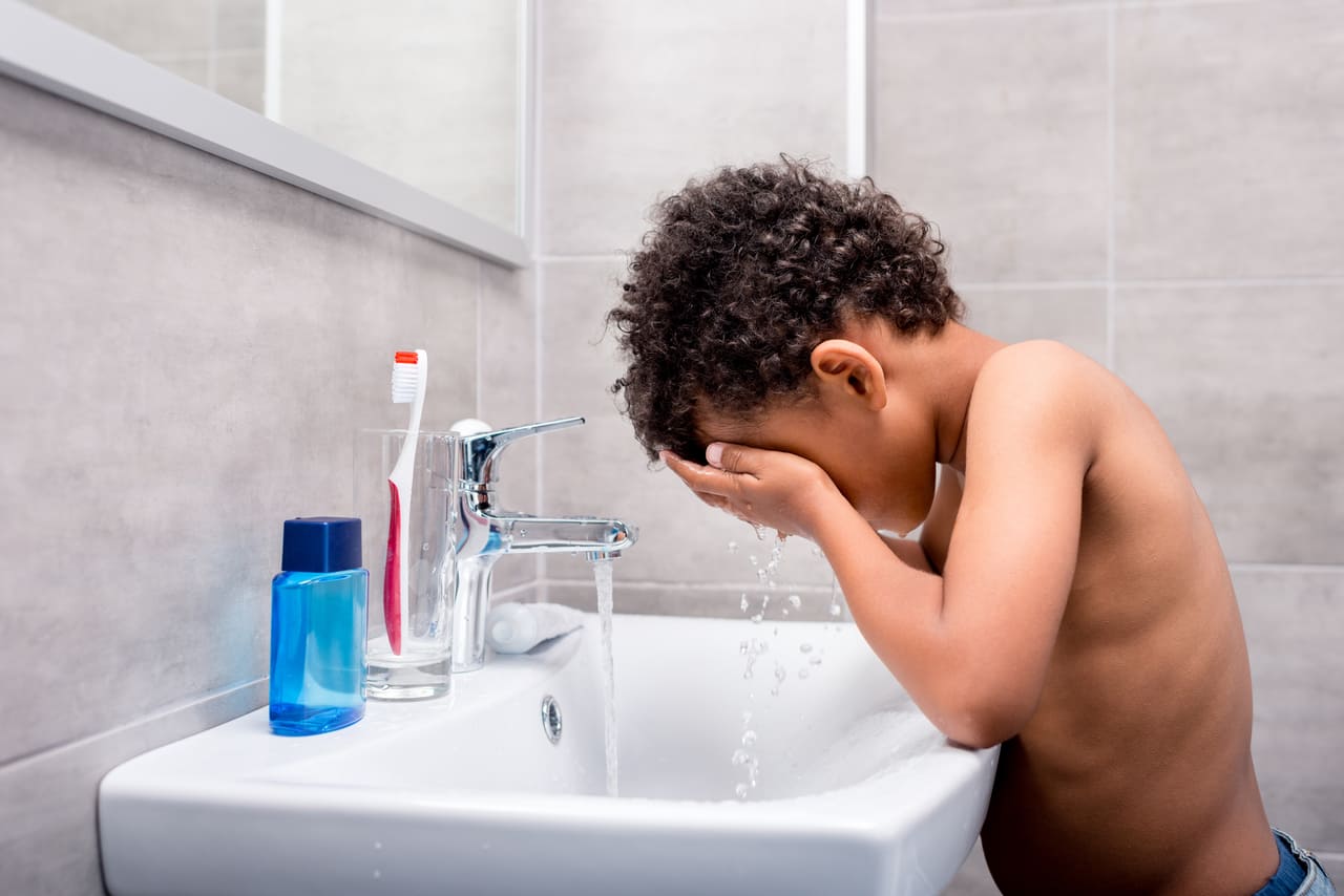 little african american kid washing face in bathro 2022 12 16 16 16 52 utc(1)