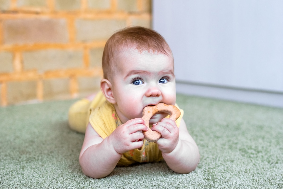 little caucasian baby girl with wooden teething to 2022 11 16 23 28 15 utc(1)