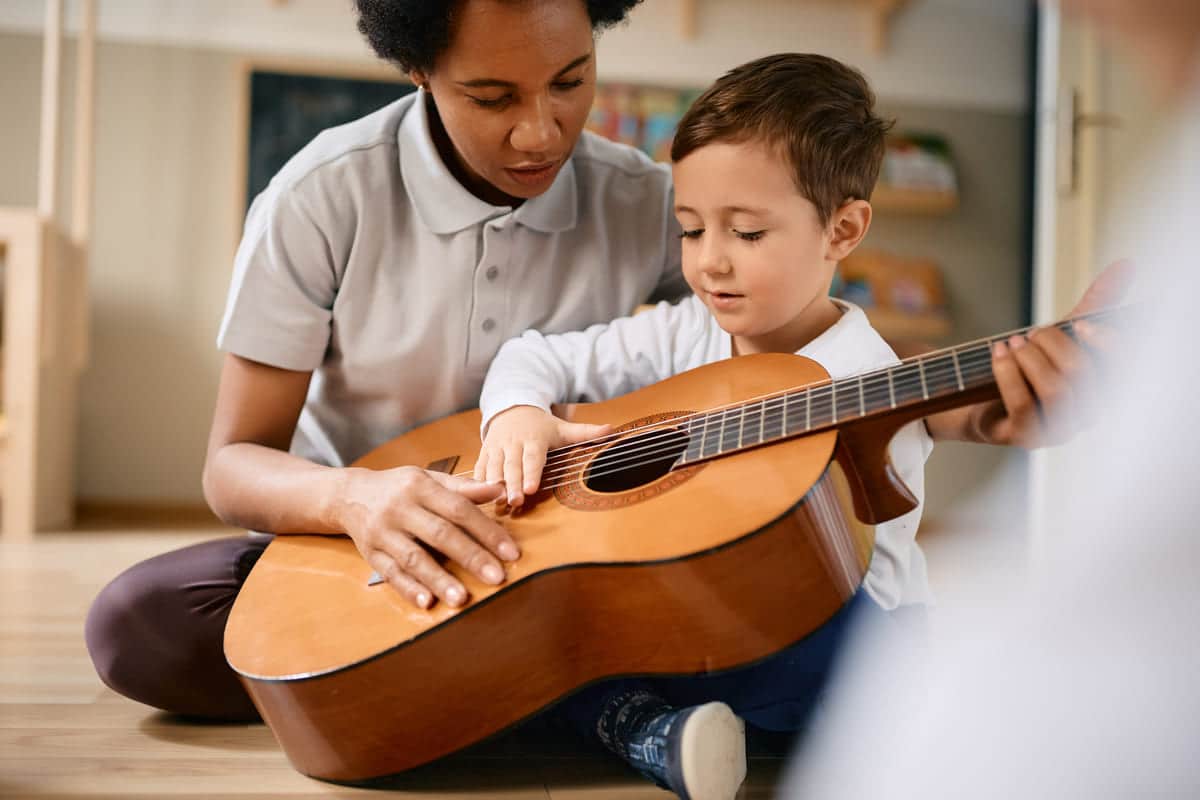 small boy learning to play acoustic guitar with he 2023 03 10 22 17 25 utc(1)(1)