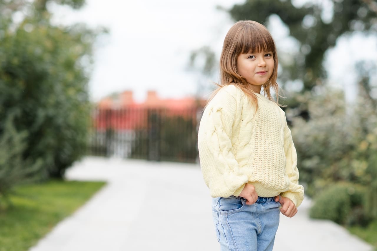 smiling kid girl wear sweater and denim pants posi 2022 11 17 15 53 24 utc