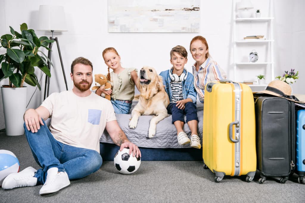 beautiful family with dog in bedroom ready for trip