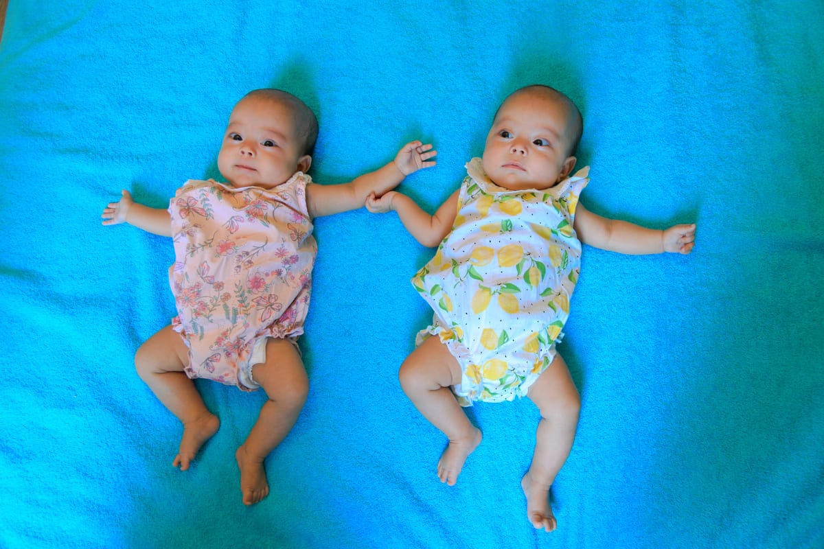 cute twin baby girls are lying on a blue blanket i 2022 06 10 08 06 15 utc(1)(1)