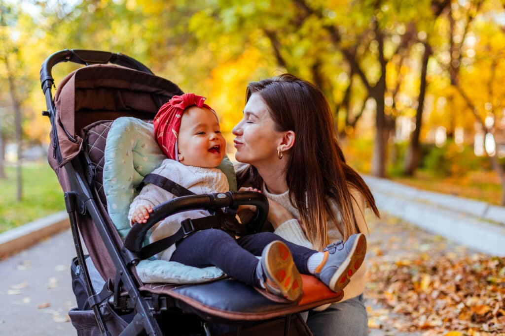 mother reaching to kiss baby in stroller 2022 10 27 18 19 18 utc(1)(1)