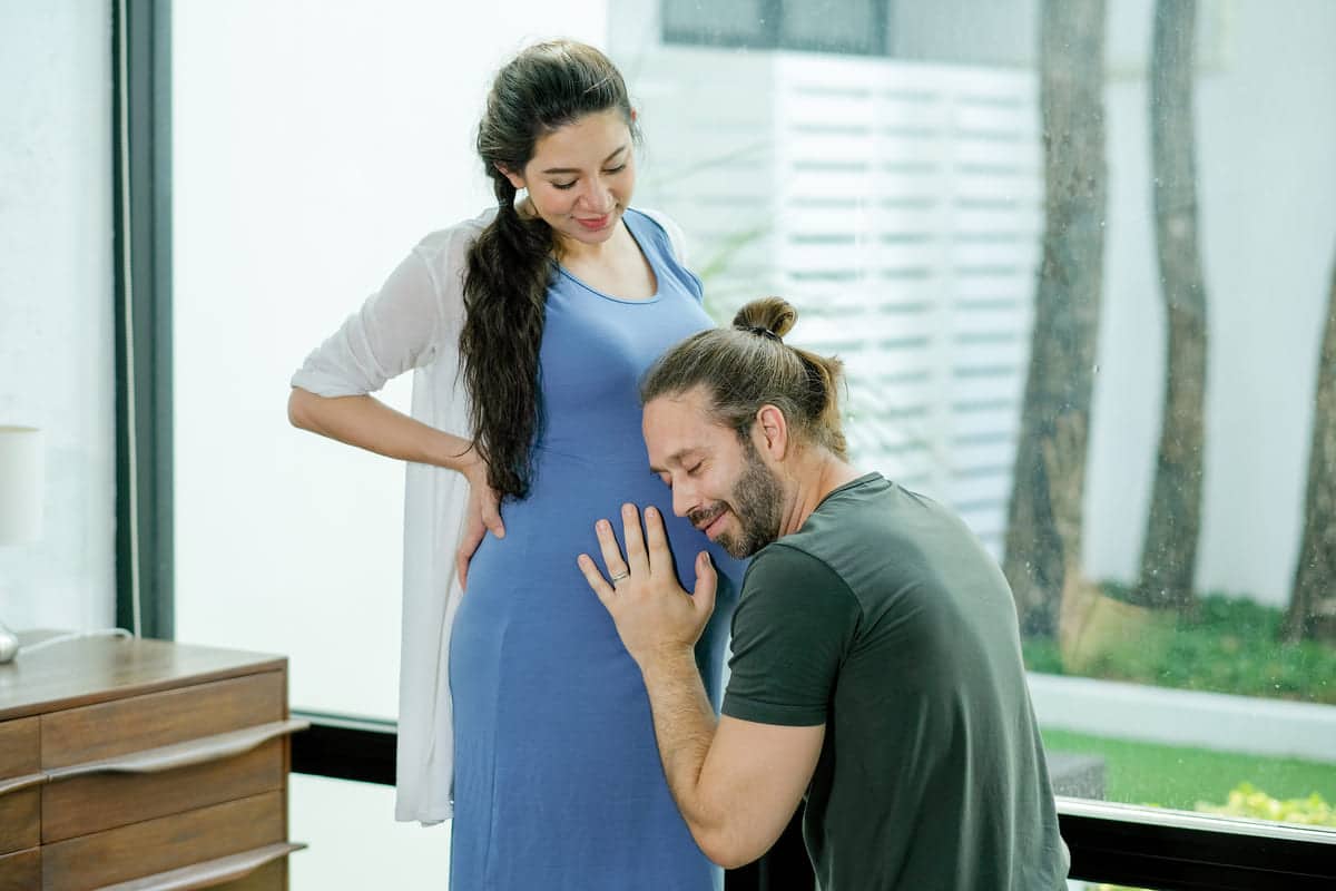pregnant woman stand with her husband who sit and 2021 10 27 19 58 14 utc(1)(1)