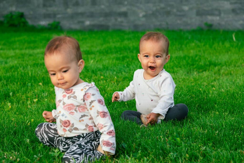 twin baby girls sitting on the lawn outside 2023 01 25 11 24 47 utc(1)(1)