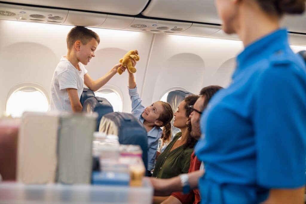 two happy kids playing with a toy during flight. family traveling together by plane