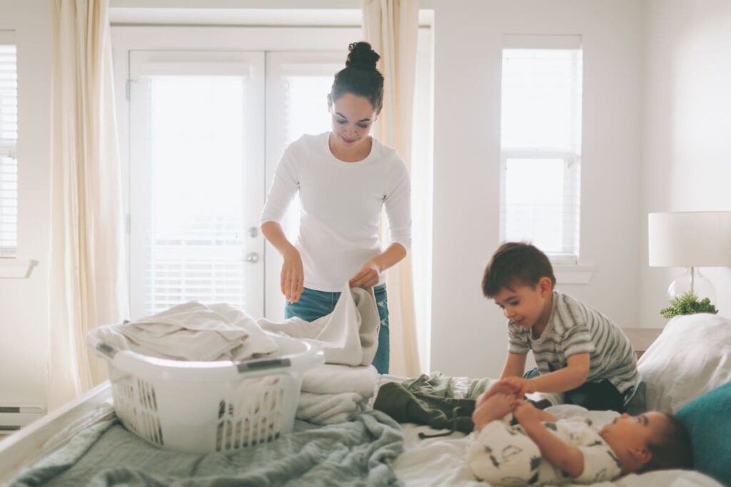 a mother folding laundry with her children in a br 2023 11 27 05 26 41 utc(1)(1)