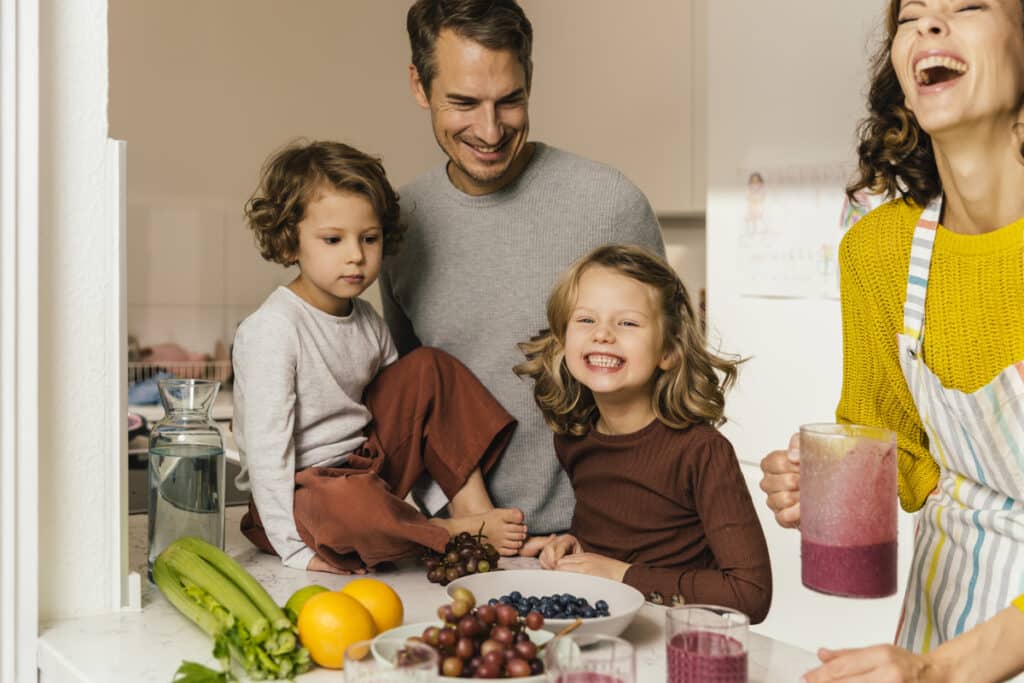 happy family making a smoothie in kitchen