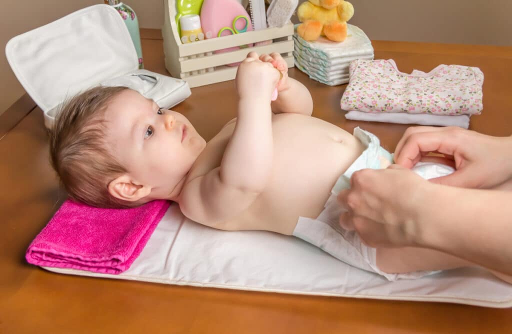 mother changing diaper of adorable baby