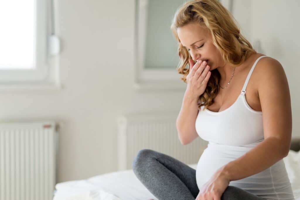 portrait of blonde pregnant woman feeling sick