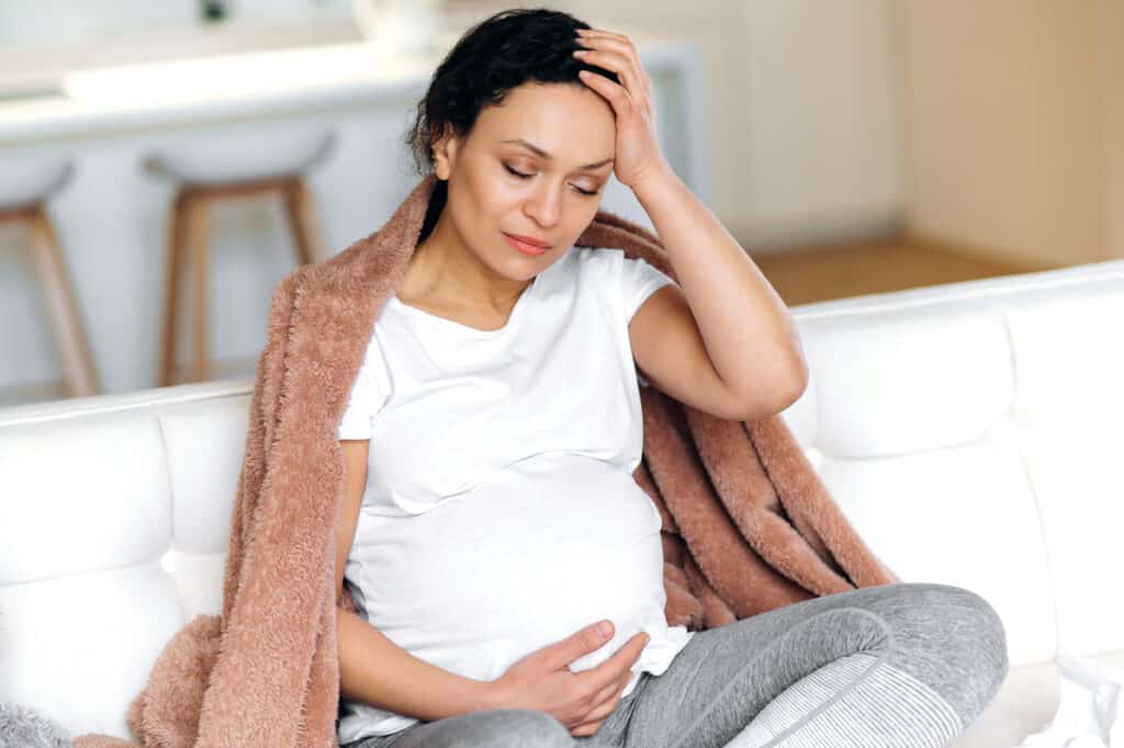 unhappy pregnant mixed race adult sick woman