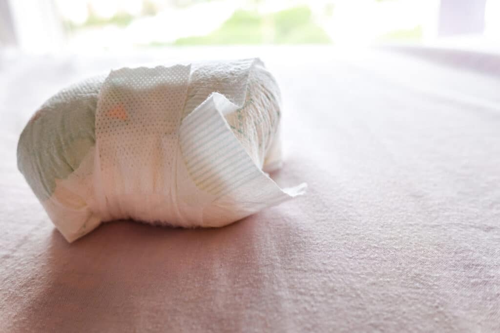 used diaper of a baby on the bed.