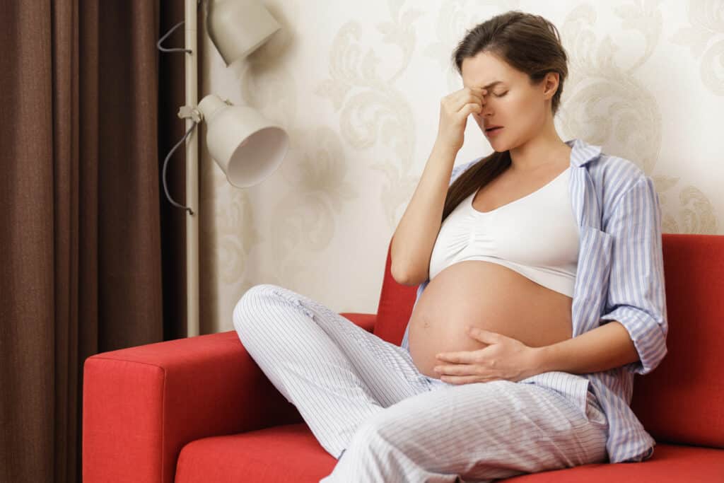 young and pregnant woman at home feels sick