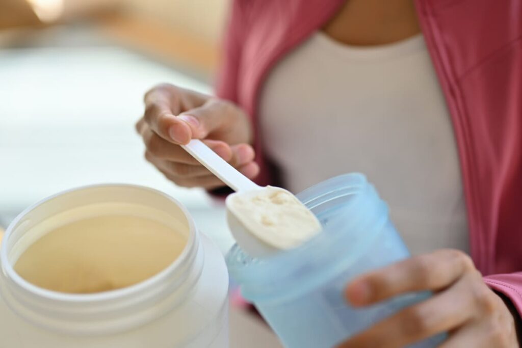 young athletic woman pouring protein powder into a 2023 11 27 05 15 52 utc(1)(1)