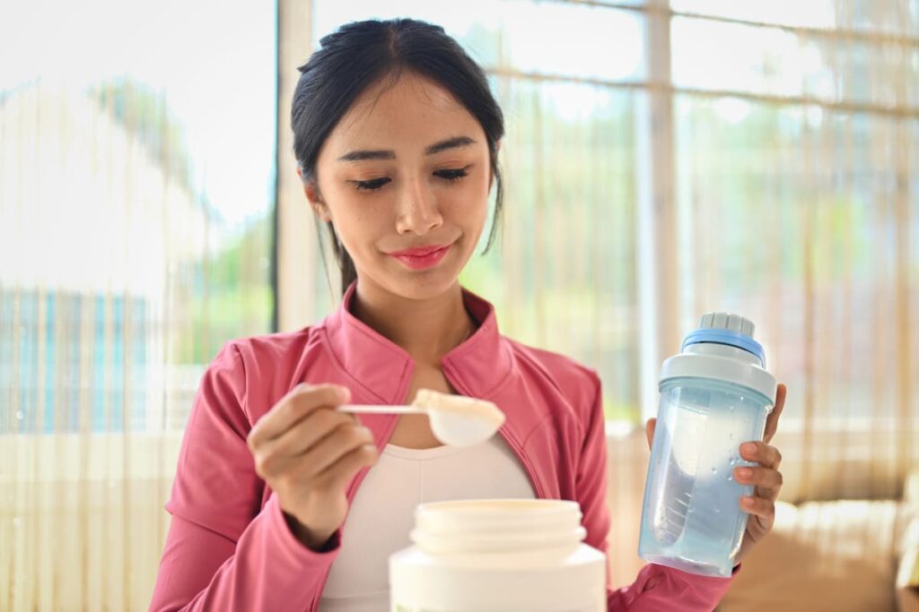 young sporty woman measuring scoop of whey protein 2023 11 27 04 55 41 utc(1)(1)