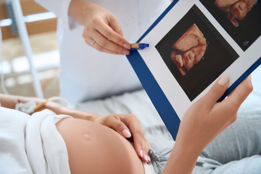 cropped of doctor showing ultrasound photo to preg 2024 02 06 14 43 41 utc