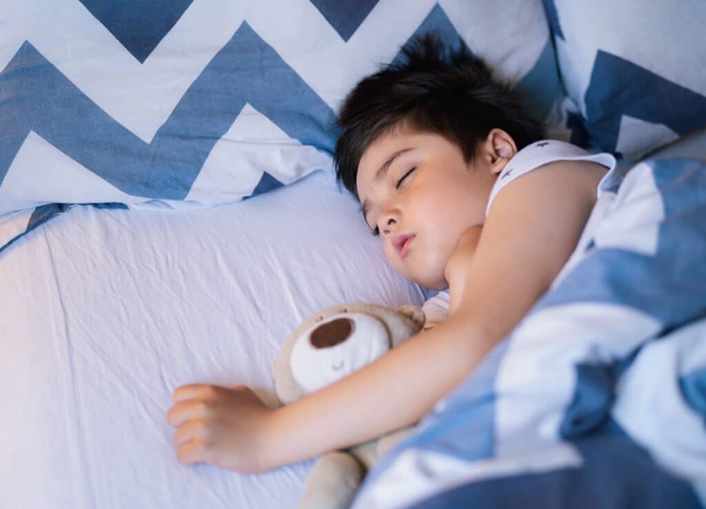 cute boy sleeping on bed with morning light,lovely child get dee