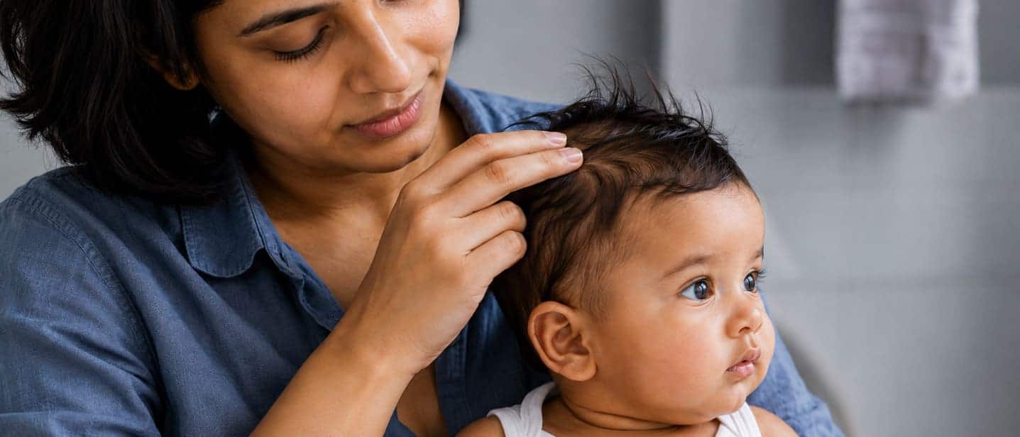 Clean fingers moving one front section of baby hair without any product