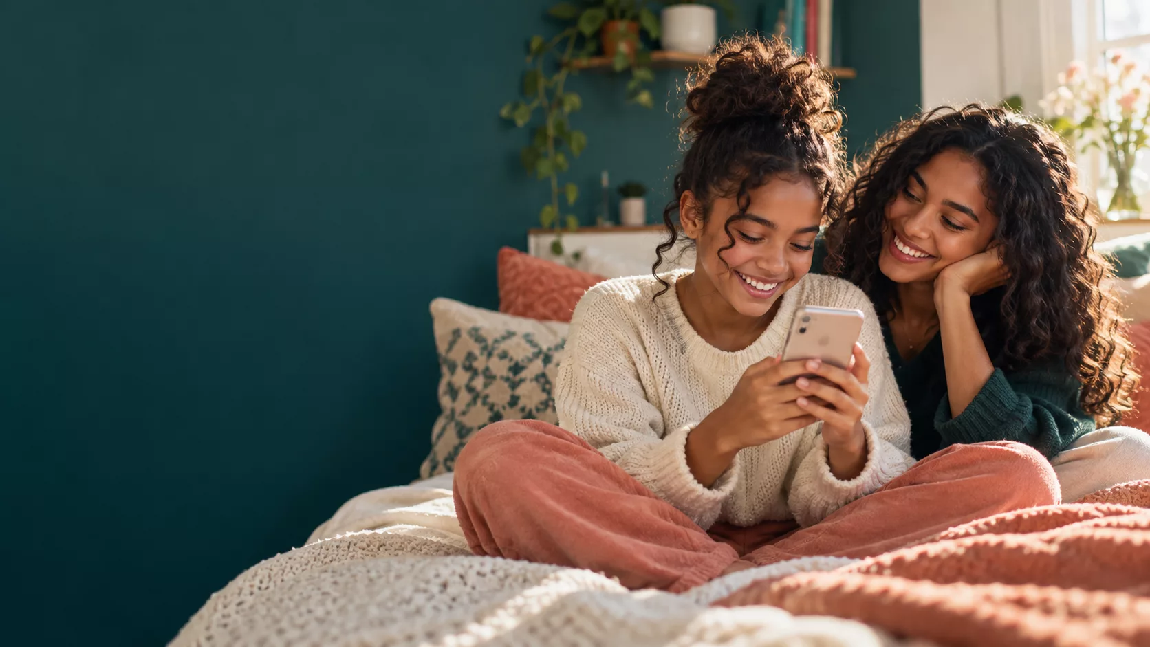 A younger sister reading a birthday text beside her older sister