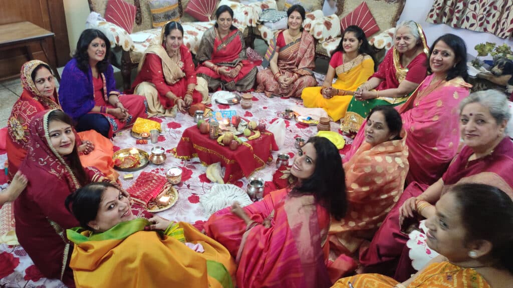 Women gathered in a family home for a traditional Karwa Chauth puja